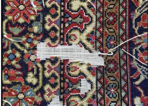 Restauration d'un tapis avec broderie traditionnelle colorée.