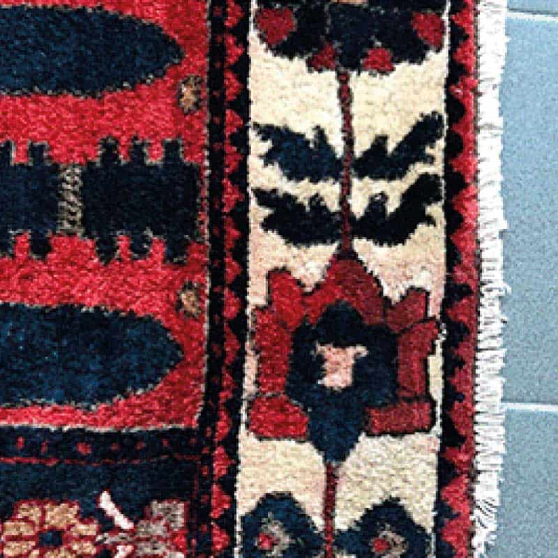 Tapis traditionnel coloré avec motifs géométriques.